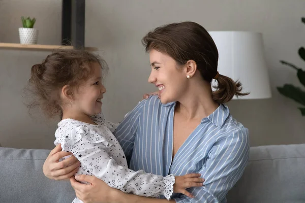 Sonriente niña charlando con el cuidado de la madre joven. — Foto de Stock