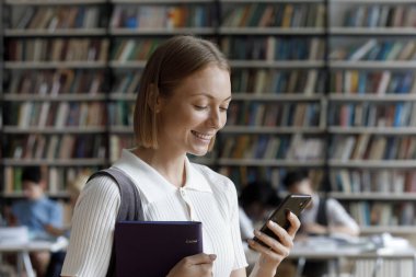 Mobil uygulamalar kullanan mutlu genç kız öğrenci..