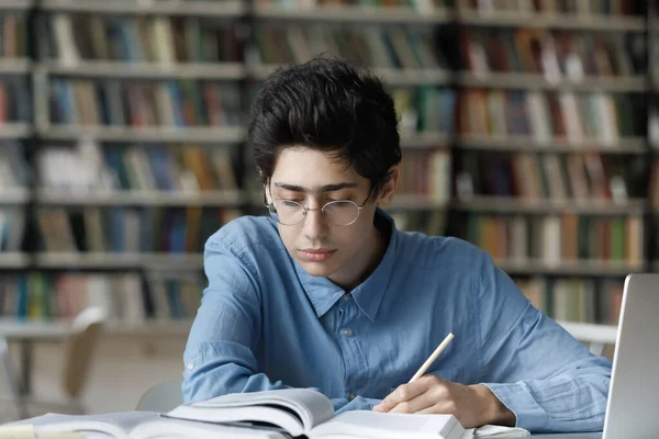 重点是在图书馆学习的忙碌的年轻犹太男生. — 图库照片