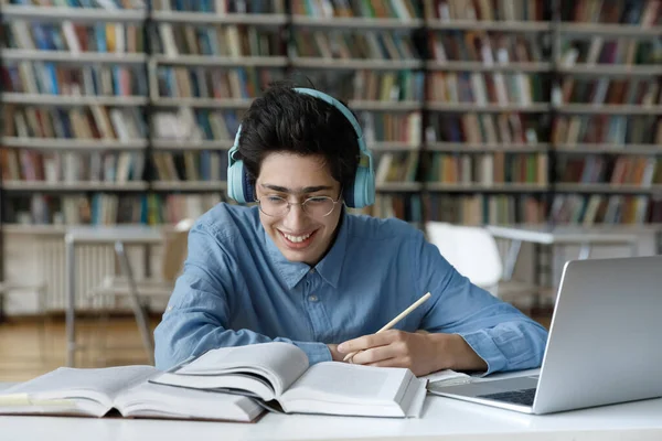 Felice studente maschio ebreo millenario che studia in biblioteca. — Foto Stock