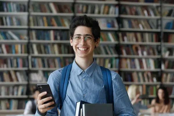 Portrait of happy Jewish male student with phone and books. — Stock Photo, Image