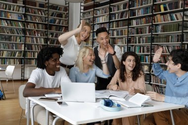 Neşeli genç çoklu etnik öğrenciler beşlik çakıyor..