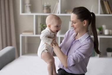 Mutlu, genç bir anne kucağında sevimli bir bebek