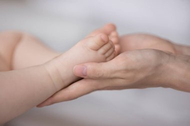 Küçük anne elleri birkaç aylık küçük ayakları tutuyor bebeğim.