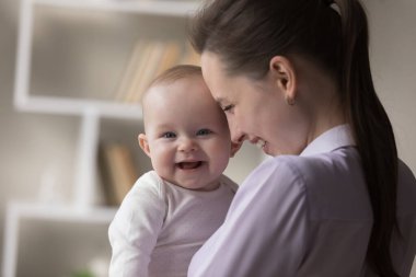 Mutlu anne kucağında sevimli komik bir bebek, kucağında çocuk.
