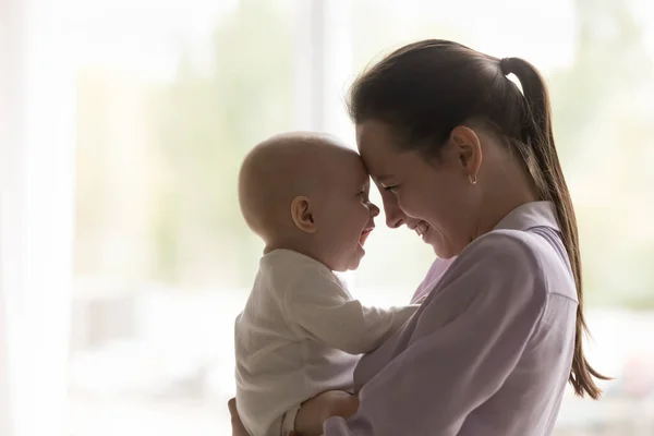 Vrolijke nieuwe moeder hebben plezier met de baby, holding kid — Stockfoto