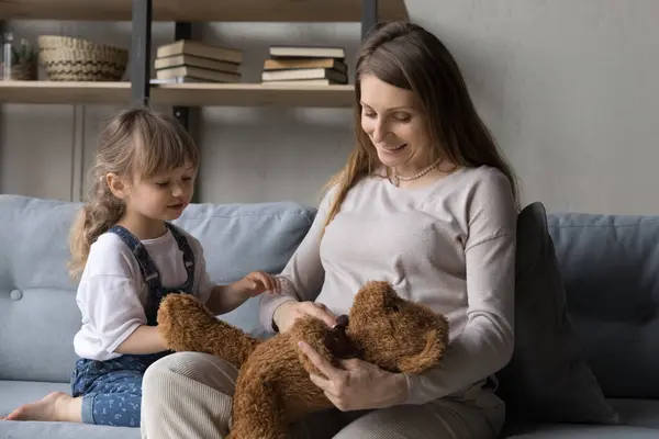 Ibu hamil positif dan anak kecil bermain boneka beruang — Stok Foto