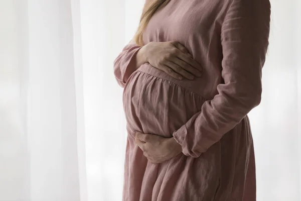 Esperando mãe vestindo vestido natural para grávida, segurando grande barriga — Fotografia de Stock