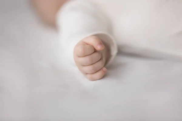 Infant sleepy baby hand wearing white clothes, sleeping on bed — Stock Photo, Image
