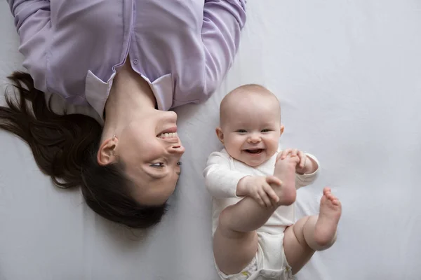 Feliz mamá y positivo adorable pocos meses bebé descansando juntos —  Fotos de Stock