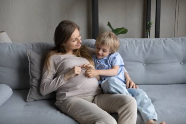 Neşeli bir anne ve küçük oğlunun kanepede sarılıp dinlenmesini bekliyorum.