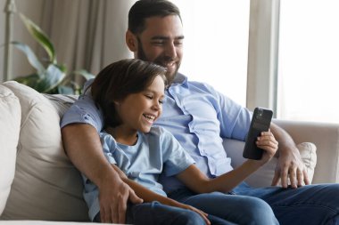 Genç baba, küçük oğlu iyi eğlenceler. Akıllı telefon kullan.