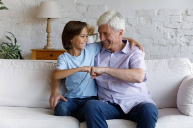 Şirin küçük çocuk. Büyükbabası yumruk tokuşturma hareketi yapıyor.