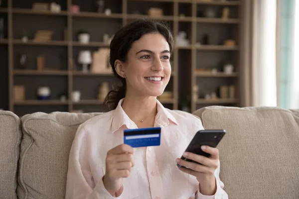Sonriente mujer hispana milenaria de compras en línea en la aplicación móvil. — Foto de Stock