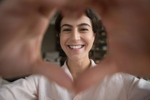 Close up sorridente giovane donna ispanica mostrando il cuore alla macchina fotografica. — Foto Stock