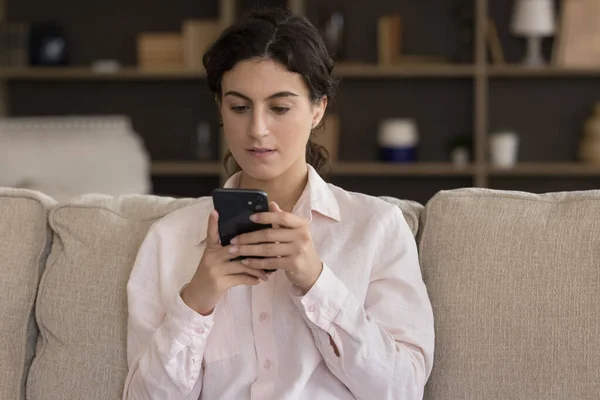 Viciado em tecnologia moderna concentrada jovem mulher hispânica usando celular. — Fotografia de Stock