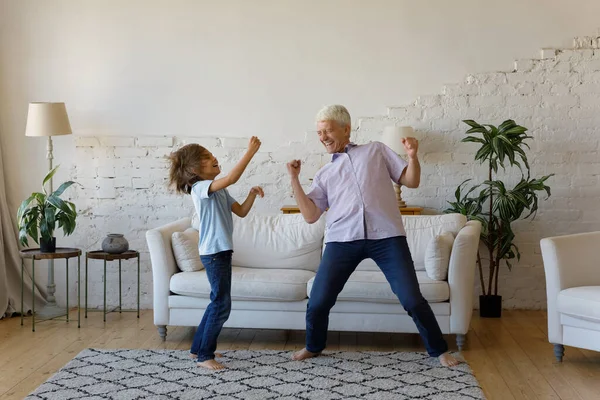Élénk nagyapa az unokája otthon táncol. — Stock Fotó