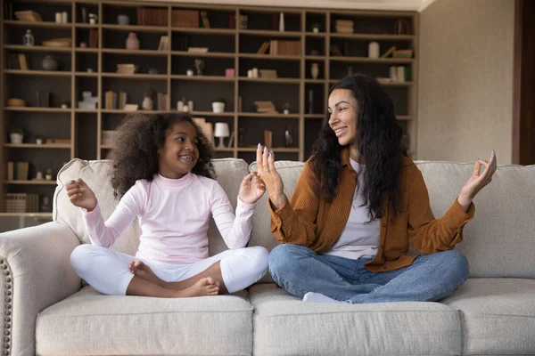 Mutlu Afrika kökenli Amerikalı anne ve kız yoga egzersizleri yapıyor..