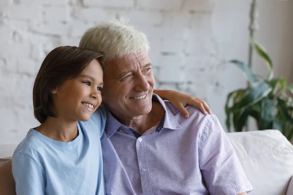 Klidný starší dědeček a malý vnuk objímající se do dálky — Stock fotografie