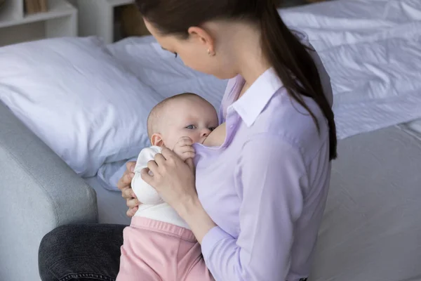 Adorable little hungry infant sucking breastmilk from mom breast — Stock Photo, Image