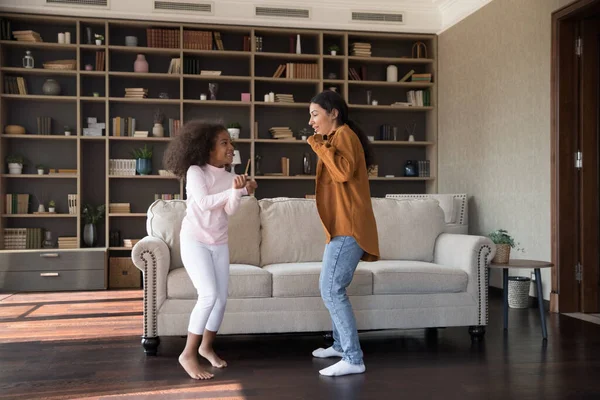 Alegre niña preadolescente bailando con madre afroamericana. — Foto de Stock