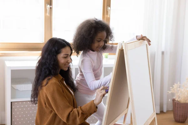 Familia afro-americană de legătură fericită desenând pe tablă albă. — Fotografie, imagine de stoc