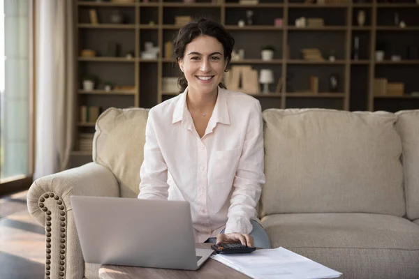 Retrato de la joven hispana sonriente propietaria de casa pagando facturas en línea. — Foto de Stock