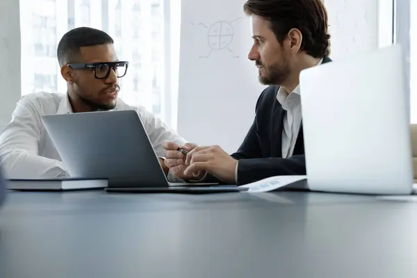 Konzentriert Diskutieren Zwei Multiethnische Geschäftsleute Computer Über Die Präsentation Von Stockfoto