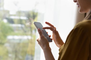 Akıllı telefon ekranı boş model ile yakın görünüm kadın omuz üzerinde, yeni mobil uygulama kullanıcısı, elektronik iş uygulaması kullanımı, mesaj yazma, e-posta yazma, mesafe iletişim konsepti