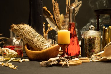 Cadılık, hâlâ cadı otlarıyla dolu. Önde seçici bir odak noktası var. Cadılar Bayramı için esrarengiz gotik ve okült cadı masası. Çeşitli sihirli nesneler ve sembollerle ayin düzenlemeleri. Gotik Cadılar Bayramı. 