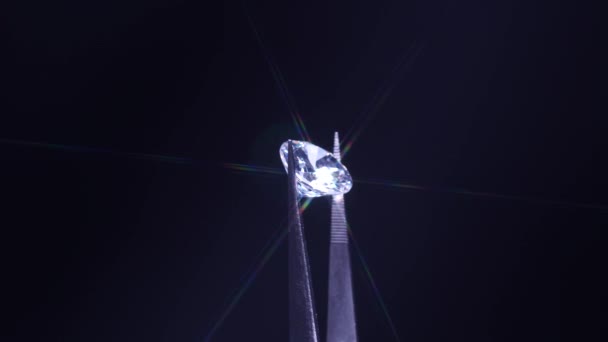 ピンセットで開催されたダイヤモンドのクローズアップ 選択的フォーカス 虫眼鏡の下で見る ラウンドカット豪華な素晴らしい石のジュエリー 婚約や結婚や結婚式の購入 品質検査 — ストック動画