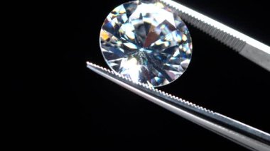 Elmas taşı cımbızla tutulur. Parlak kesim ya da metal kuyumcu maşasında kristal taş. Stüdyoda mücevher yapımı ya da hobi. Makro teftiş ve lüks mücevher üretimi..
