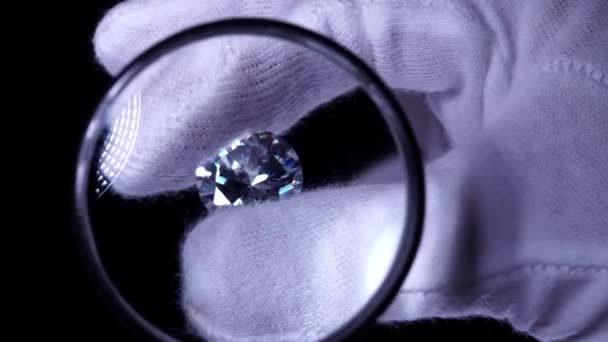 ホワイト手袋のゴールドスミス手は 豪華な鮮やかなダイヤモンドの品質を検査します 選択的焦点マクロ 光の中で星の光で輝く宝石 婚約指輪または結婚指輪用ラウンドダイヤモンド — ストック動画