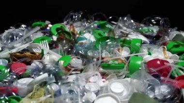 Plastik şişe parçaları, bardaklar, mantarlar, pipetler, su ve şampuan şişeleri, krem ambalajlar ve masaya atılan diğer bir kerelik çöpler. Çevre kirliliği, geri dönüşüm, atık yönetimi sorunu.