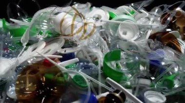 Plastik şişe parçaları, bardaklar, mantarlar, pipetler, su ve şampuan şişeleri, krem ambalajlar ve masaya atılan diğer bir kerelik çöpler. Çevre kirliliği, geri dönüşüm, atık yönetimi sorunu.