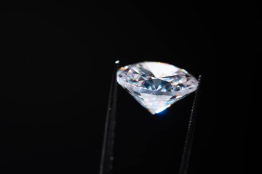 Cımbızdaki elmas seçici odaklanma, inceleme ve parlak kesim kristal cilası kalitesini analiz etme. Stüdyoda profesyonel kuyumcu el yapımı. Makro çekim, yüzeysel derinlik.