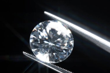 Metal kuyumcu cımbızında tutulan elmas seçici odak, cila kalitesi ve kontaminasyonun mükemmel taş kesimi denetimi. Sanayi ve moda uygulamaları için doğal karbon materyali.. 