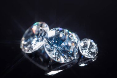 Büyük ve küçük lüks elmaslar seti, seçici odaklanma. Endüstriyel ve moda uygulamaları için değerli ve pahalı taşlar. Siyah masaya dağılmış parlak elmaslar. Görünüm ve denetim.