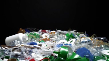 Tek kullanımlık plastik çöp. Geri dönüşümsüz plastik atıkla çöp sahalarının aşırı kirlenmesine dikkat çekmek. Masanın üzerinde biyolojik olarak çözünemeyen zehirli bir çöp var. Çevre sorunları.