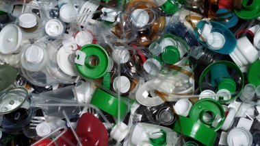Tek kullanımlık plastik çöp. Geri dönüşümsüz plastik atıkla çöp sahalarının aşırı kirlenmesine dikkat çekmek. Masanın üzerinde biyolojik olarak çözünemeyen zehirli bir çöp var. Çevre sorunları.