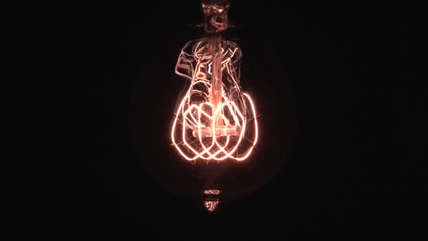 Edison glödlampa avslöjar långsamt i fokus och detaljer. Glider under vintage glödlampa glöder och lysa upp närbild makro vy underifrån med bokeh effekt. 4K. — Stockvideo