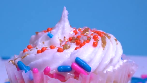 Cupcake Con Crema Blanca Glaseado Azúcar Sobre Fondo Azul Macro — Vídeo de stock