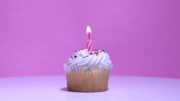 Cupcake Met Brandende Feestelijke Kaars Witte Room Suikerglazuur Roze Achtergrond — Stockvideo