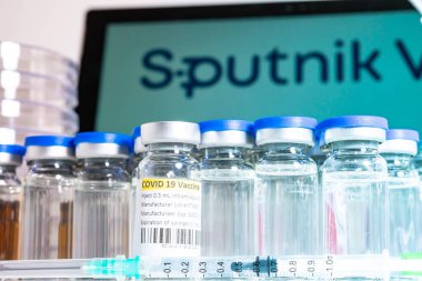 Toronto, Ontario, Kanada 20 Nisan 2021. Sputnik V aşı ismi bulanık. Rus aşısıyla dolu cam şişeler ve şırıngalar. Coronavirus COVID-19 tedavisi için araştırma. Klinik değerlendirme.