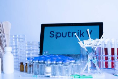 Toronto, Ontario, Kanada - 20 Nisan 2021: Sputnik V aşı adı bulanık ve içinde Gam-COVID-Vac içeren şırıngalar bulunan şişeler. Rus Coronavirus aşısı konsepti. Sığ alan derinliği.