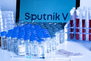 Toronto, Ontario, Kanada 20 Nisan 2021. Sputnik V aşı ismi bulanık. Rus aşısıyla dolu cam şişeler ve şırıngalar. Coronavirus COVID-19 tedavisi için araştırma. Klinik değerlendirme.
