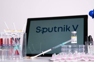 Toronto, Ontario, Kanada 20 Nisan 2021. Sputnik V aşı ismi bulanık. Rus aşısıyla dolu cam şişeler ve şırıngalar. Coronavirus COVID-19 tedavisi için araştırma. Klinik değerlendirme.
