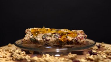 Sağlıklı bir mısır gevreği veya müsli 'nin üzerine taze bal dökülen uç makrolar. Enerji fitness aktivitesi yaşam tarzı yiyecekler. Bal damlıyor. Seçici odak.