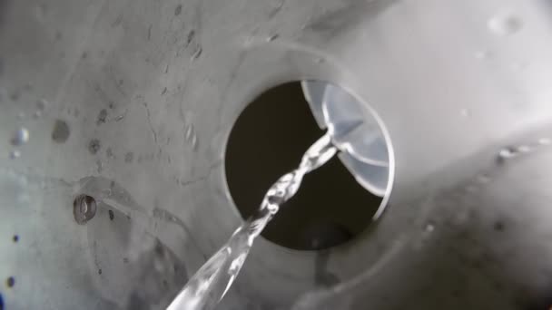 Стакан воды. Чистая питьевая вода наливается в стекло из кувшина или банки. Медленный вид снизу. Чистая вода, льющаяся из кувшина в прозрачное стекло. Выстрел со дна стекла. Селективный фокус. — стоковое видео