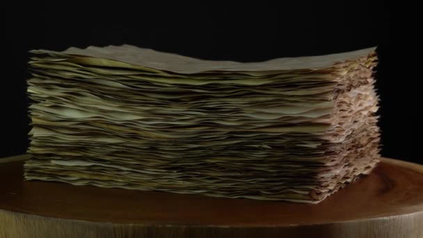 Starověké pergamenové papíry rotující na dřevěném stole, stará ošlehaná spálená zásoba papíru. Papír pro kaligrafické záznamy a tvorbu knih. — Stock video